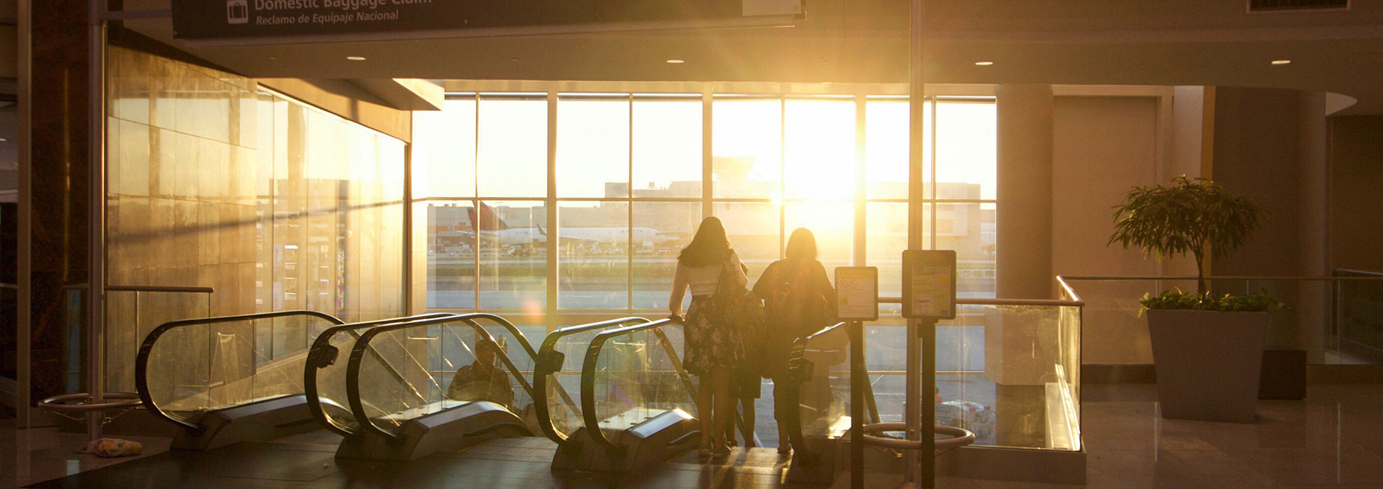 passengers-traveling-silhouettes-sunlight-airport-SEAYFGA