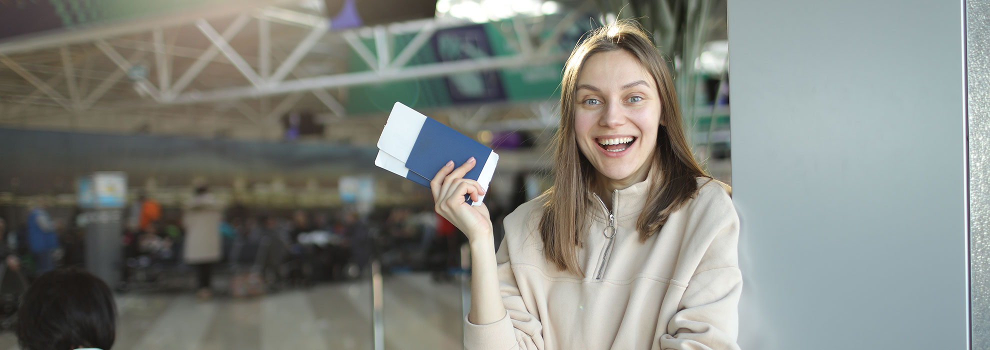 portrait-of-happy-young-woman-holding-passport-and-2EMUGAY